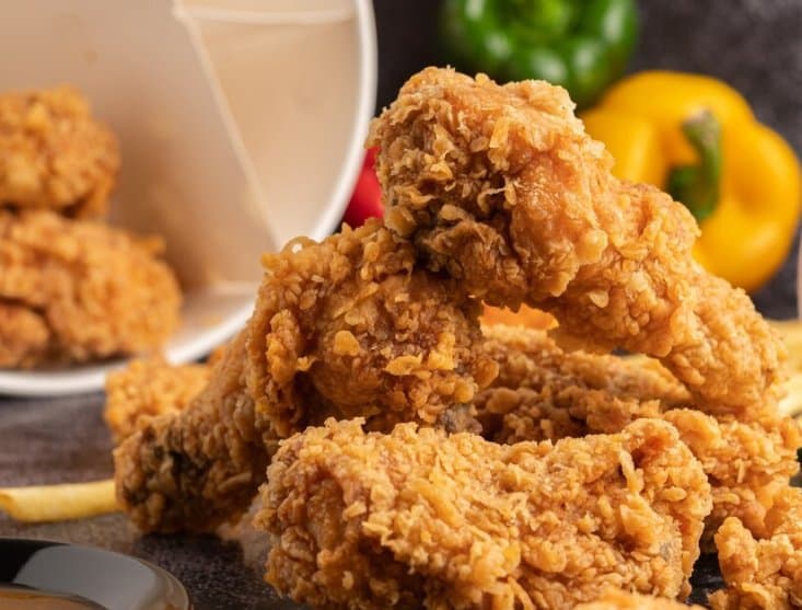 A pile of fried chicken spilling from a bucket
